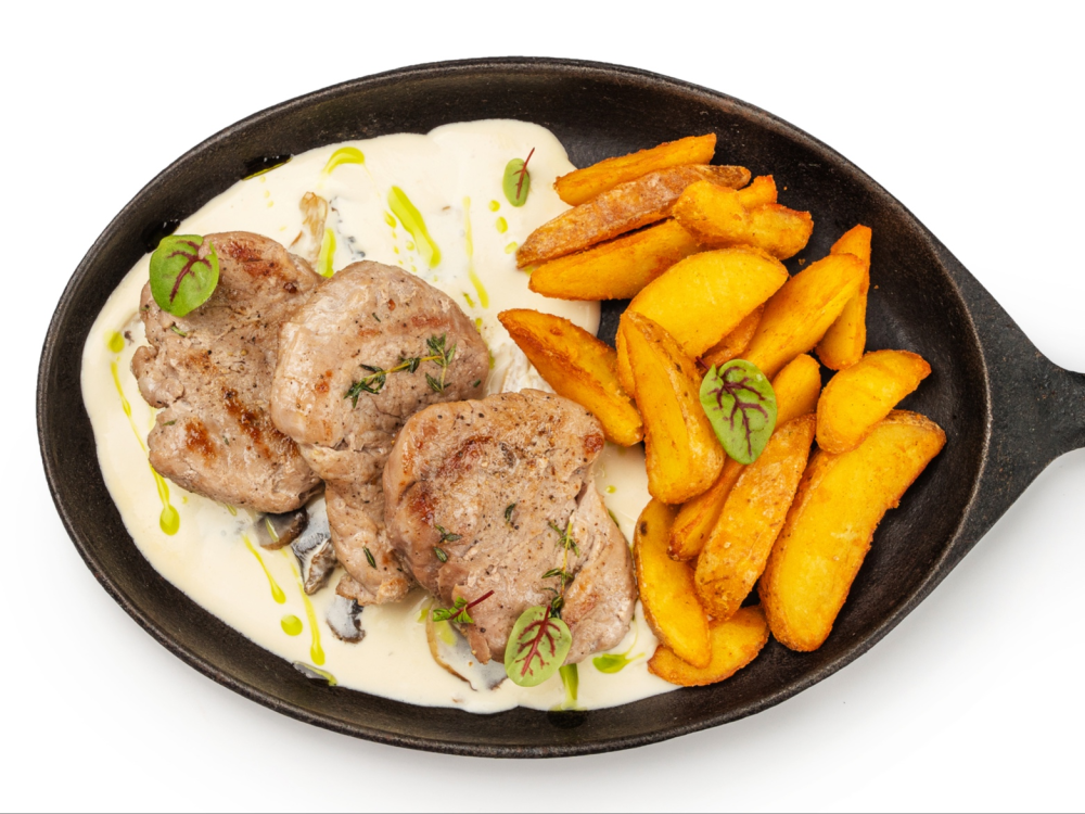 Медальоны из свинины картофельными дольками и грибным соусом
