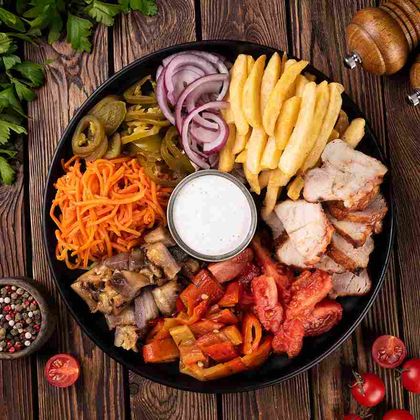 Шаверма на тарелке с овощами на мангале